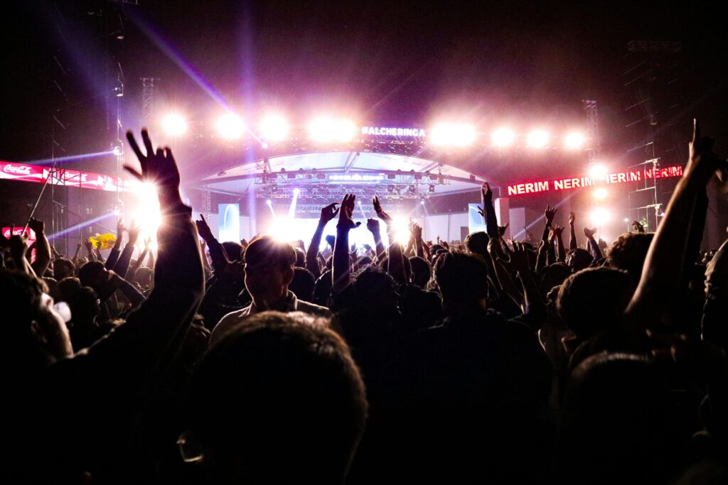 Energetic crowd enjoying a live concert under bright stage lights in Guwahati, India.